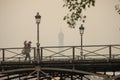 Long shot of man walking across the Pont des Art Paris towards the Louvre