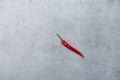 Long shot of a single red chili pepper on a stone surface background Royalty Free Stock Photo