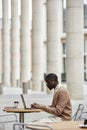 Long shot of young male solopreneur typing on laptop keyboard