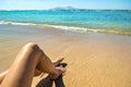 Long slim young woman legs relaxing lying down and sunbathing on sand tropical beach under hot sun in summer. Skincare, sun aging Royalty Free Stock Photo