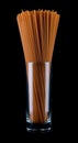 Long spaghetti isolated on a black background. Tomato pasta in a glass glass. Colored spaghetti Royalty Free Stock Photo