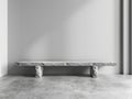 A long stone bench is in a room with a white wall Royalty Free Stock Photo