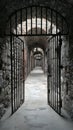 Historic Prison Corridor with Stone Arches and Iron-Barred Doors Royalty Free Stock Photo