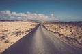 Long straight asphalt road with sand and rocks desert around - travel and destination adventure concept - beautiful landscape and Royalty Free Stock Photo