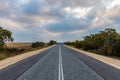 Long straight Australian road with now cars and colorful clouds