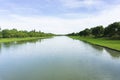 Long and straight canal in a rural landscape summer season and along Canal with trees along the way and clear skies Royalty Free Stock Photo