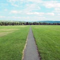 Long straight footpath stratching to the distance in a park Royalty Free Stock Photo