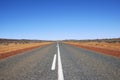 Long straight road in Australian Outback with read sand Royalty Free Stock Photo