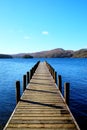 Very long beautiful wooden jetty, jutting out from the centre of Royalty Free Stock Photo