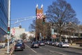 A long street with cars driving and cars parked surrounded by bare winter trees, office buildings and street signs Royalty Free Stock Photo