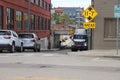 A long street with parked cars and semi truck with yellow street signs and red brick buildings in downtown Memphis