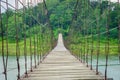 In a long suspension wooden bridge over natural lake Royalty Free Stock Photo