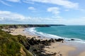 The long sweep of a wild rugged beach and coastline on a sunny day at low tide. With cliffs behind. Marloes Sands, Pembrokeshire.