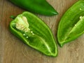 Long sweet green pepper cut in half on rustic style wood background. Pepper seeds. Royalty Free Stock Photo