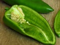 Long sweet green pepper cut in half on rustic style wood background. Pepper seeds. Royalty Free Stock Photo