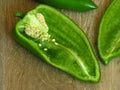 Long sweet green pepper cut in half on rustic style wood background. Pepper seeds. Royalty Free Stock Photo