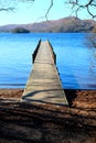 Long symetrical wooden foot jetty, jutting out from the centre o Royalty Free Stock Photo