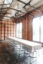 Long table with black steel chairs inside brick wall room decorated in loft style