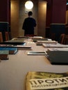 Long table with books and a man standing back in the background