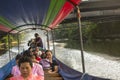 A long-tail boat carrying local people passing on the Chao Praya River.