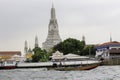Long-tail boat passing Wat Arun Ratchawararam Ratchaworawihan