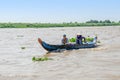 Long-tail Mekong boat with a Cambodian family manoevring it on the Mekong River