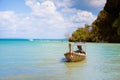Long-tailed boat with products and goods. Moored at the shore on a tropical sandy beach. Against the background of blue sky with Royalty Free Stock Photo
