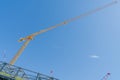 Long tall bright yellow crane on construction job