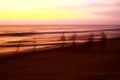 Ghostly silhouettes of blurred fishermen catch up their net during sunset on beach Royalty Free Stock Photo