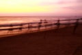 Ghostly silhouettes of blurred fishermen catch up their net during sunset on beach Royalty Free Stock Photo