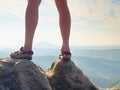 Long tired naked legs in hiking sandals on peak. Hiking in sandstone rocks, hilly landscape Royalty Free Stock Photo