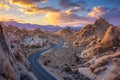 A long and twisting road stretches through the arid landscape of a desert, A highway snaking through a rocky desert scape at Royalty Free Stock Photo