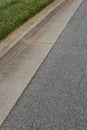 Long view of street, asphalt beside formed concrete curb and grass