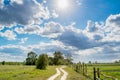 Long village way near the fields during sunny day Royalty Free Stock Photo