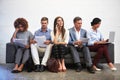 The long wait...Full length shot of a group of businesspeople sitting in a line on a sofa. Royalty Free Stock Photo