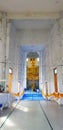 Long walkway and pathway access to big golden monk statue in church at Thai temple. Royalty Free Stock Photo