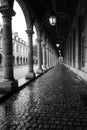 A long walkway with pillars and a cobblestone floor, AI