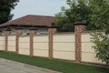 A long wall of a fence made of gray concrete