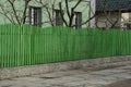Long wall of a private fence of green wooden boards