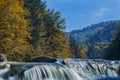 Long waterfall and river with rocks high in the mountains. Autumn mountains landscape. Idea for outdoor activities, travel.