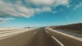 Long way asphalt straight road from ground pov. Vehicle driving and traveling outdoors concept. Blue sky in background. Going to a