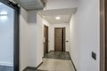 Long white empty corridor in interior of entrance hall of modern apartments, office or clinic