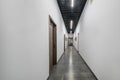 Long white empty corridor in interior of entrance hall of modern apartments, office or clinic