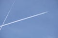 Long white plane traces in the clear cloudless blue sky and big passenger supersonic aircraf with four jet engines flying high Royalty Free Stock Photo