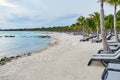 The long white sand at Cancun beach in Mexico with deck chairs line-up along with coconut palm trees Royalty Free Stock Photo