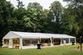 Long white tent for wedding party in the woods