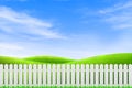 Long white wooden fence with Green grass meadow field and little hill. Royalty Free Stock Photo