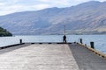 Long wide pier into Lake Wakatipu with mountain backdrop