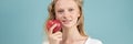Long width banner with portrait of young smiling woman with red apple. Fresh face Royalty Free Stock Photo