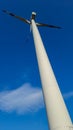 Long wind turbine from an optically interesting oblique view . Frog\'s eye view photographed from the bottom right . Royalty Free Stock Photo